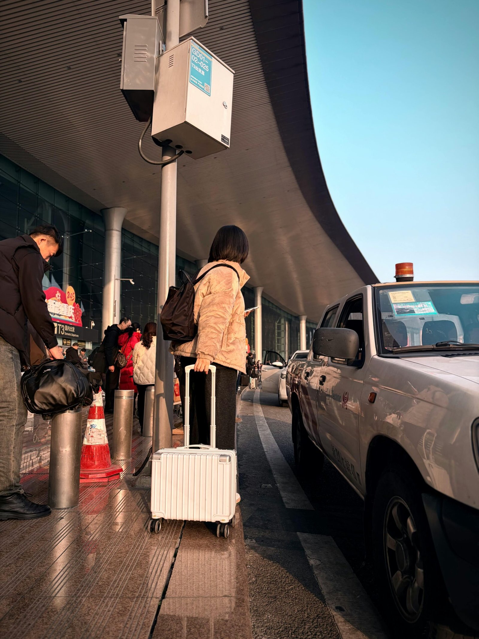 Adult at airport curbside with suitcase, ready to travel. Modern terminal scene.
